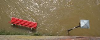 Park bench and street lamp during flood