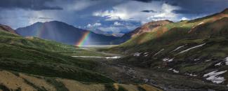 Photo of a rainbow over mountains in Alaska