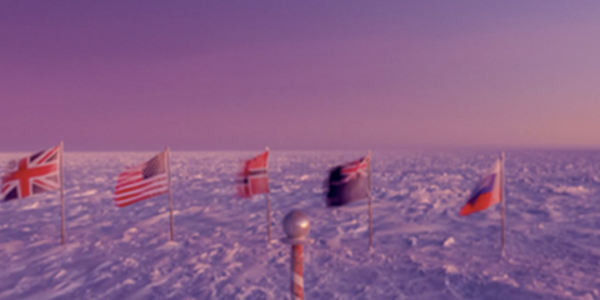 Eleven flags of world countries stood up on poles in the snow tundra near   the iconic candy-striped marker at the South Pole during sunrise in September 2021.
