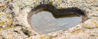 Photo of a heart carved into rock courtesy of iStock