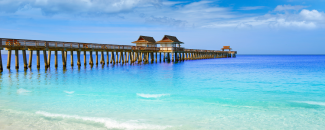 The ocean with a pier stretched far out into the clear blue water.