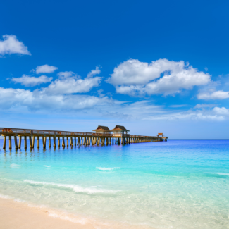 The ocean with a pier stretched far out into the clear blue water.
