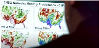 Photo of NCEI scientist Anthony Arguez reviewing ENSO Climate Normals maps on a computer screen.