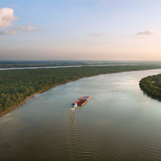 Aerial view of cargo being transported by boat down the Mississippi River.