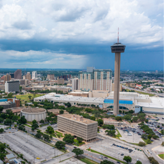 Aerial view of San Antonio, TX skyline with storm clouds and a thunderstorm with heavy rain in the background.