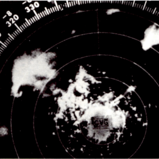 Black and white image of storms on WSR-57 radar scope on April 3, 1974. A “hook echo” or hook-shaped storm cell indicating a severe and potentially tornadic storm can be seen in the upper left corner of the image.
