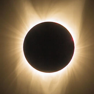 Image of a solar eclipse with a halo of light around it.