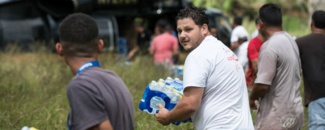 Local residents form a chain to deliver food and water to their community during humanitarian aid efforts in Puerto Rico following Hurricane Maria in 2017