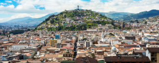 Green mountains overlook the buildings of Quito, Ecuador.