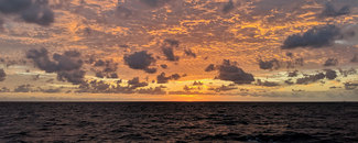 Photo of ocean horizon with tinted orange sky
